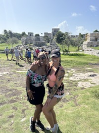 two women posing for a picture in front of an ancient ruin