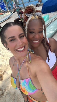a woman in a bikini standing next to a surfboard