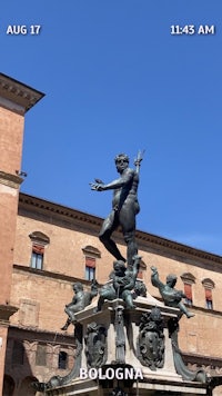 a statue in front of a building with a blue sky