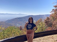 a woman posing for a picture on the side of a road