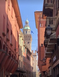 a narrow street with buildings and a clock tower